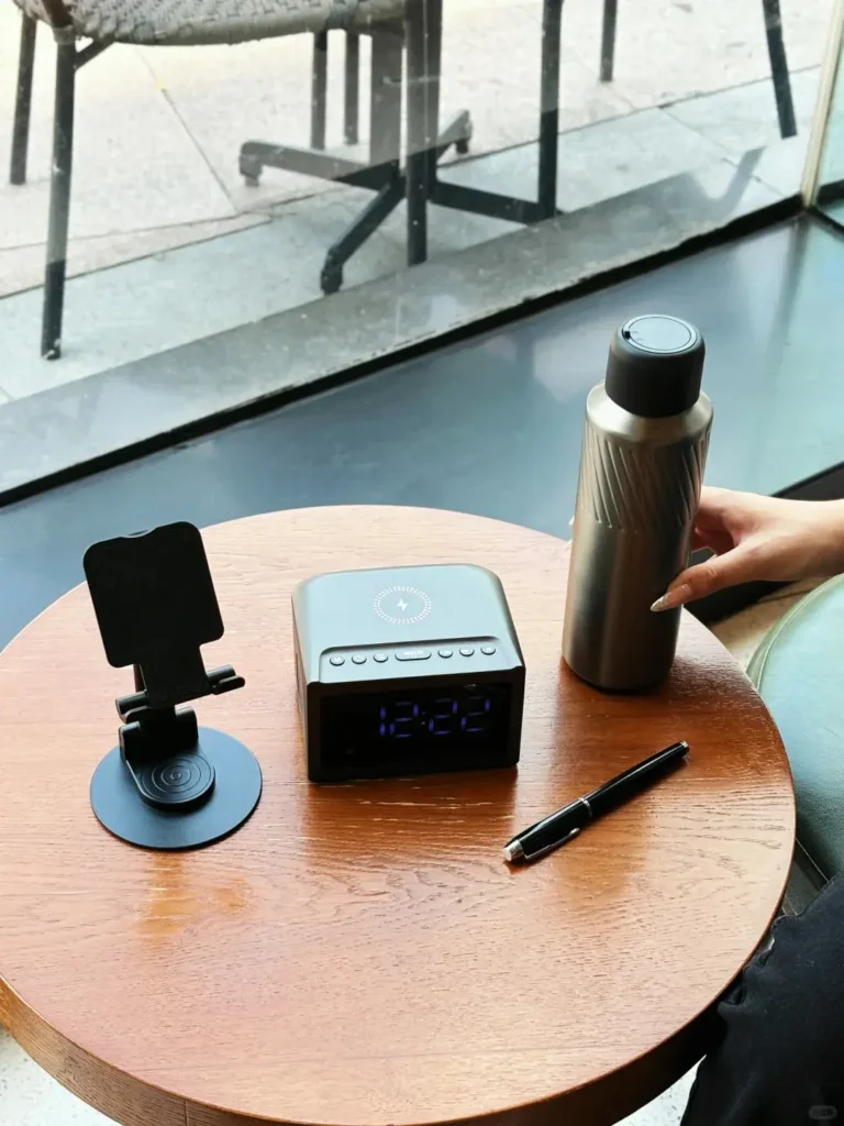 Corporate gifts set with tumbler, pen, wireless charging clock, and phone stand displayed on desk for executive gifting.