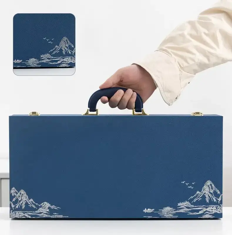 Person preparing to carry a blue gift box with a custom design printed on the lid