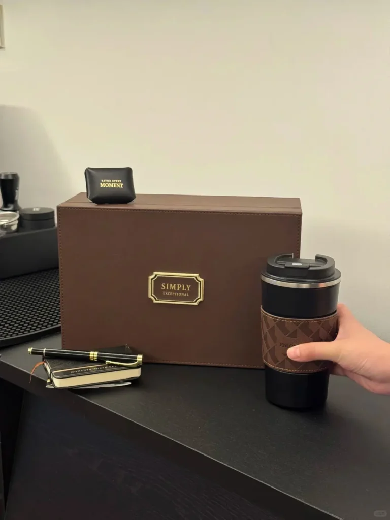 Premium brown leather gift box with coffee cup, leather notebook, pen, and coffee beans displayed on a desktop