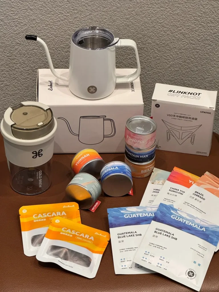 Employee appreciation coffee gift set displayed on a stool with pour-over kettle, coffee cup, tea bags, and drip coffee filters — creative employee appreciation gift ideas