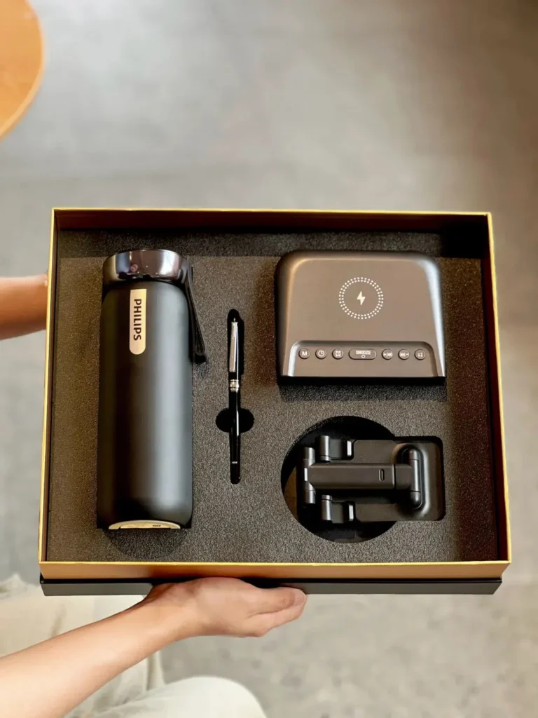 Open Philips tech employee appreciation gift box with thermal mug, wireless charging Bluetooth speaker, foldable phone stand, and metal pen — creative employee appreciation gift ideas