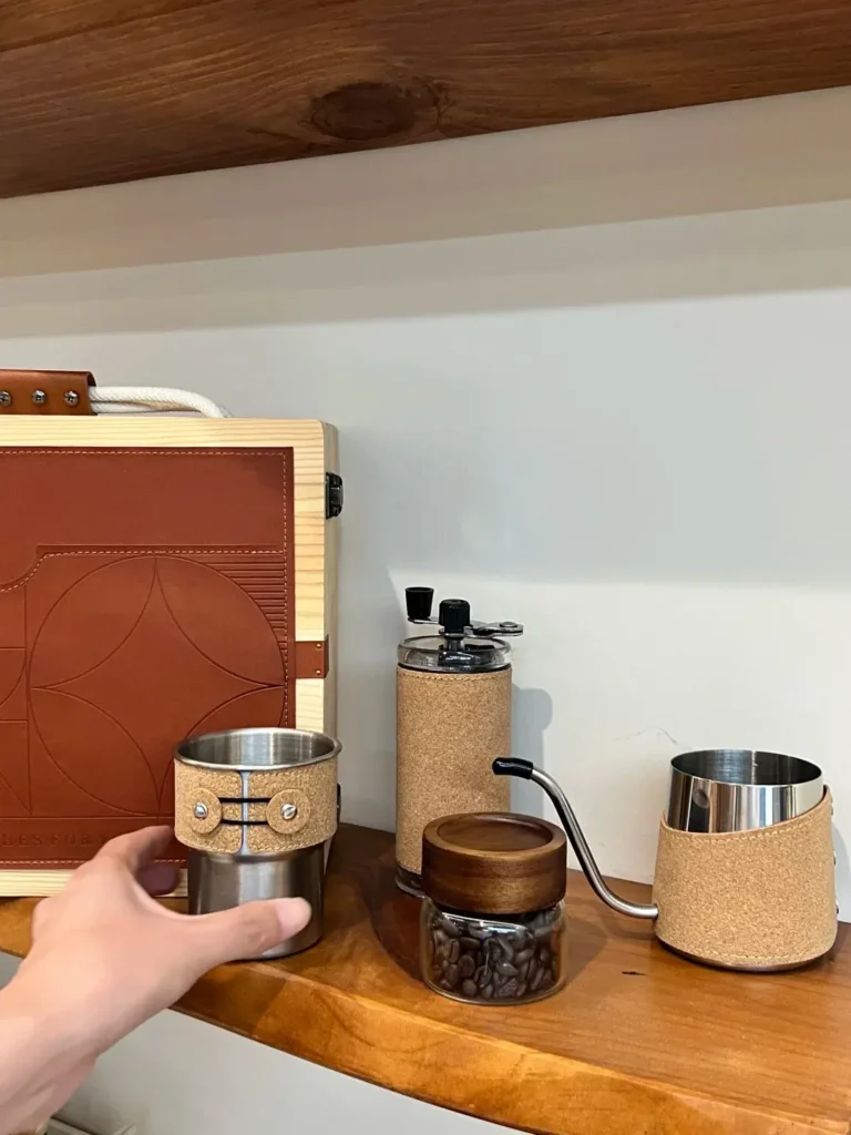 Premium executive coffee gift set displayed on a wooden desk — featuring a leather and wood-grain gift box, coffee cup, manual grinder, coffee pot, and coffee beans. A refined choice for executive gifts and corporate gifting ideas.