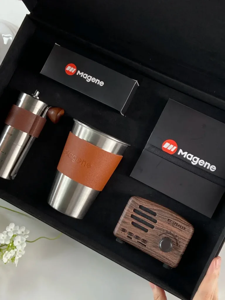 Luxury CEO gift box opened, showing hand grinder coffee machine, coffee cup, vintage radio, and phone stand neatly arranged