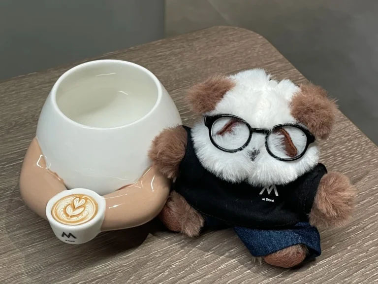 M Stand gift with purchase ideas featuring a branded plush stationery and creative coffee cup — thoughtful GWP that enhances brand connection.