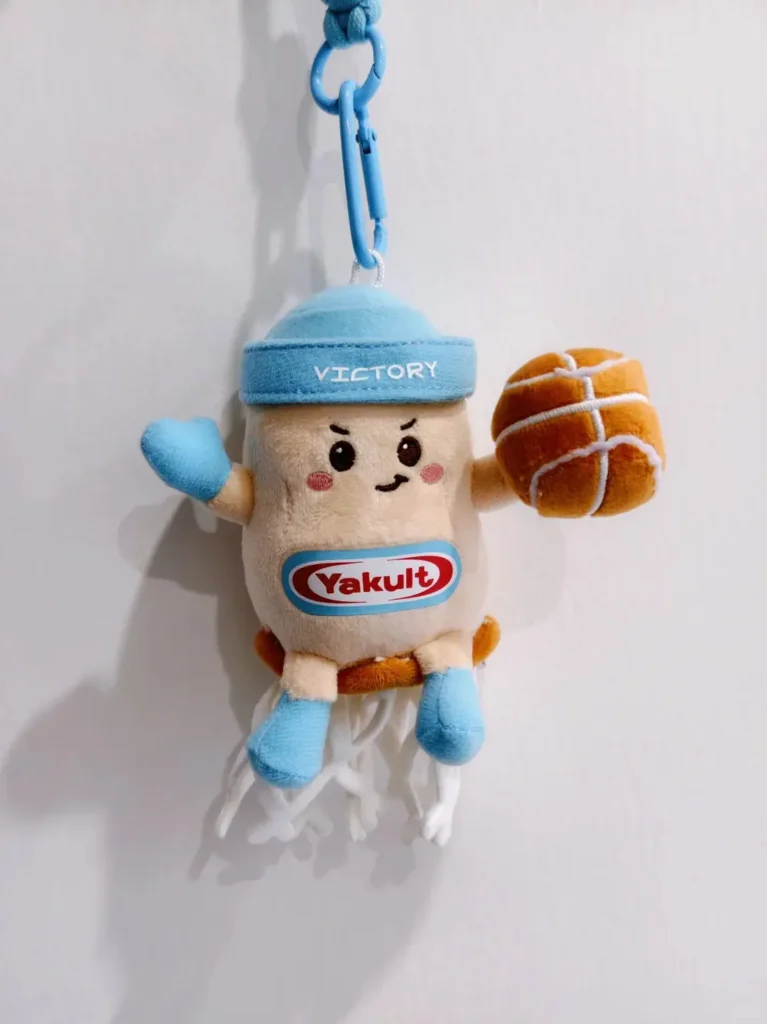 Yakult gift with purchase plush toy wearing a “Victory” cap, holding a basketball, and featuring the Yakult logo on its belly — a fun and memorable promotional gift that connects emotionally with customers.