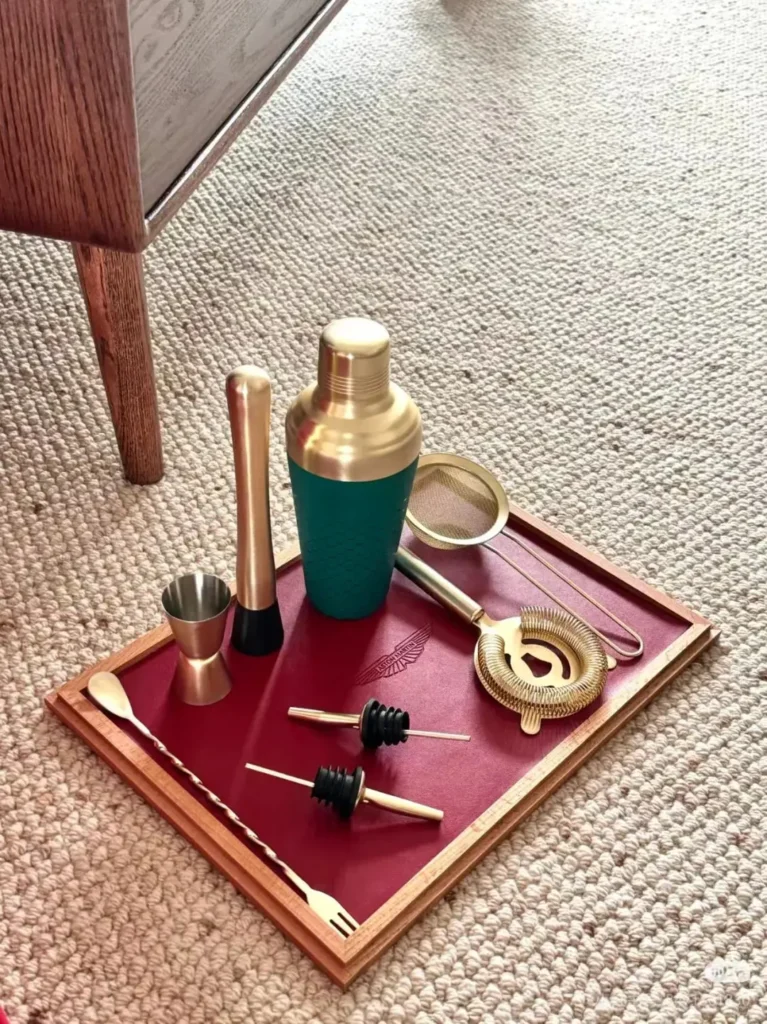 Aston Martin New Year customer appreciation cocktail shaker set displayed on carpet with leather tray, instruction card, greeting card, and three-layer gift box