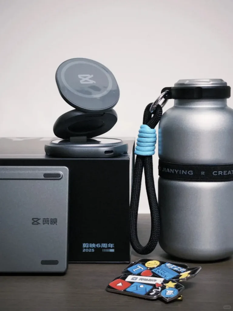 Silhouette-style employee anniversary gifts displayed on a desk, including a silver tumbler, magnetic wireless charging phone stand, foldable Bluetooth keyboard, and fridge magnet.