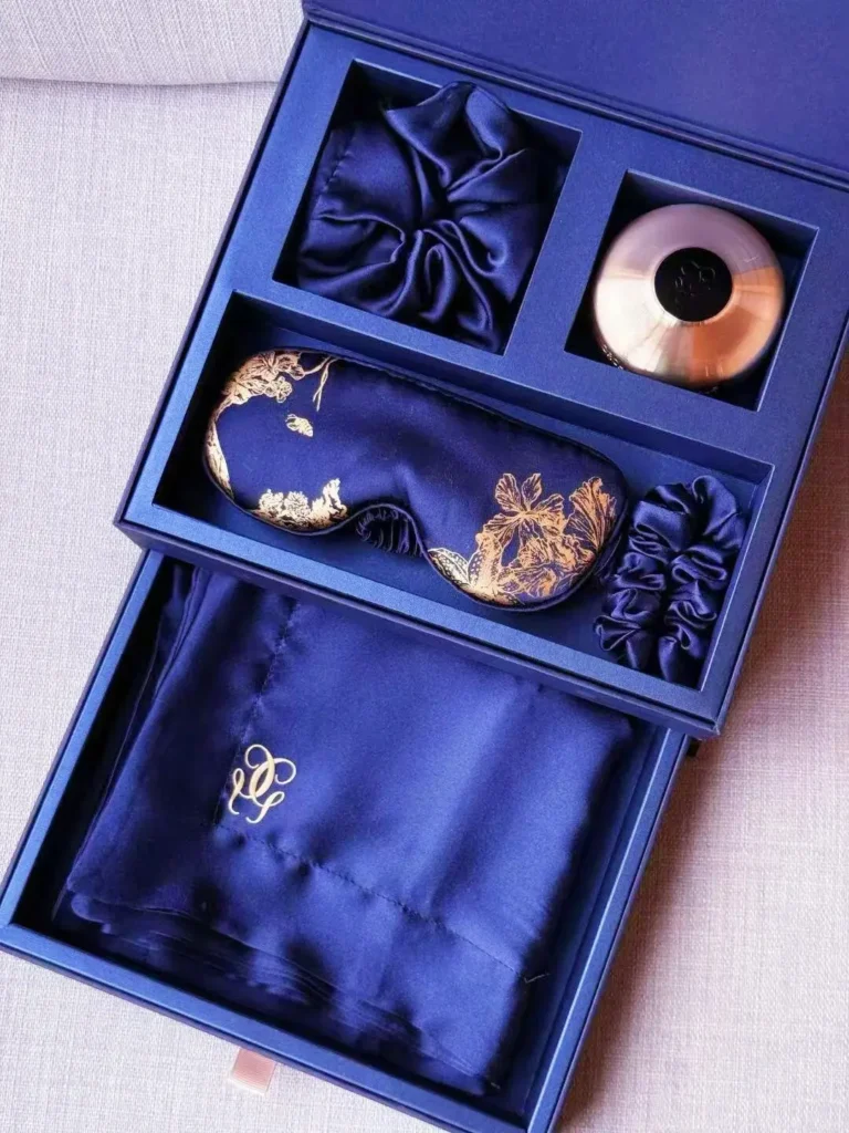 Guerlain silk travel gift set drawer with eye mask, neck pillow, hair tie, and additional silk scarf as unique promotional giveaways