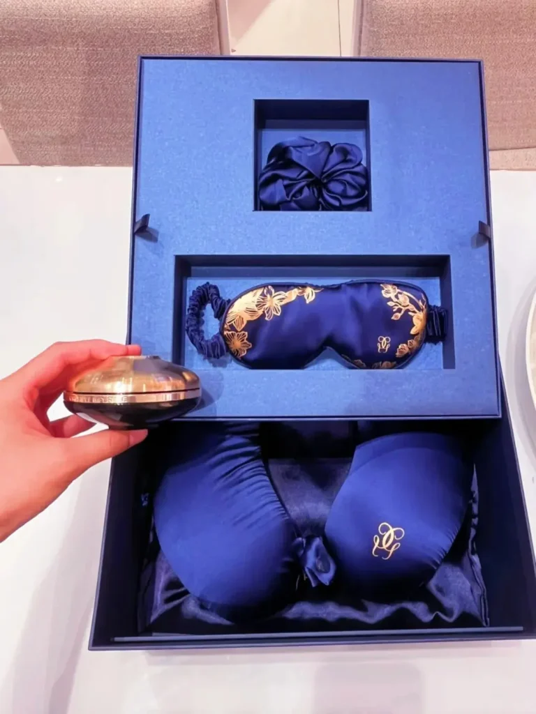Guerlain silk travel gift set with eye mask, neck pillow, hair tie, and scarf as unique promotional giveaways
