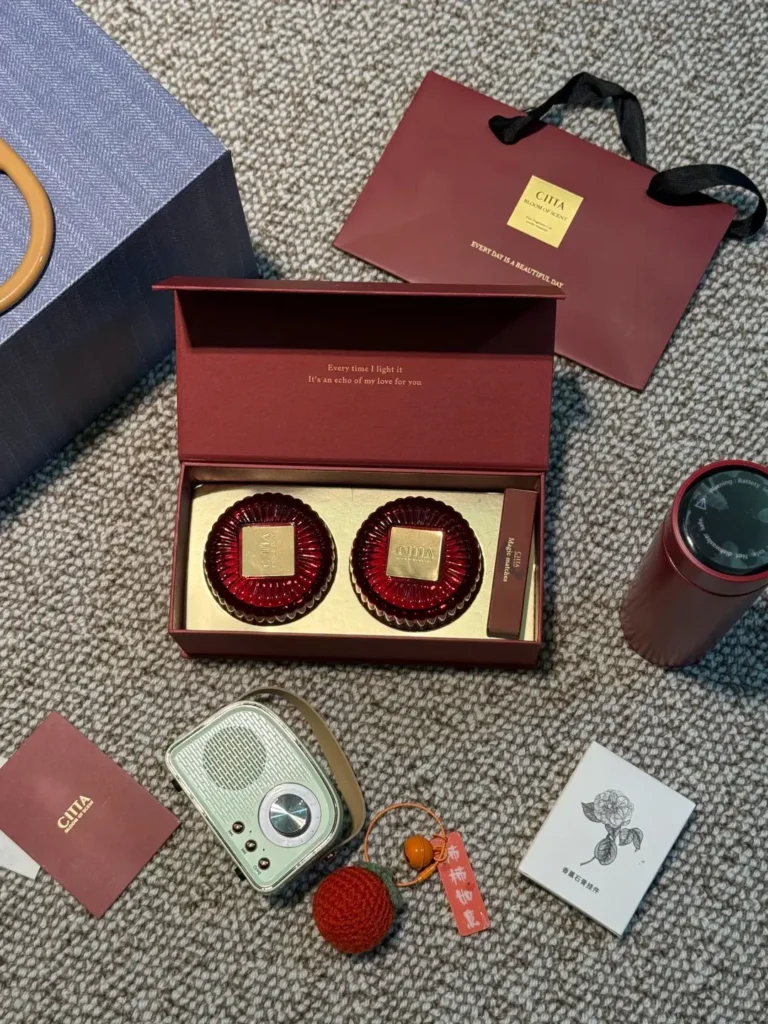 Open 2026 New Year employee gift box on a desk, showing aromatherapy set, light blue Bluetooth speaker, insulated mug, and hanging diffuser as custom employee gifts.