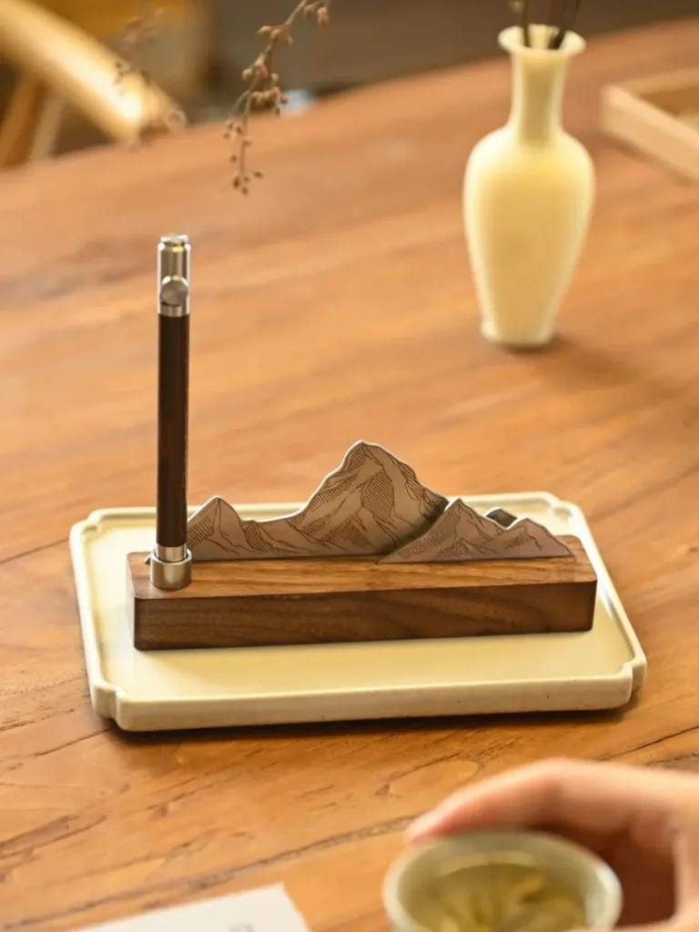“Reaching the Pinnacle” fountain pen displayed on a walnut and stainless steel mountain-shaped pen holder, part of an elegant gift set — perfect as unique trade show giveaways or trade show gifts.