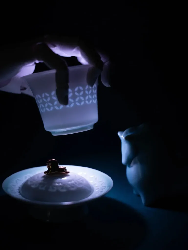 هدايا الشركات الفاخرة: صياغة تجارب لا تُنسى للعملاء والمديرين التنفيذيين 6 طقم شاي أزرق فاخر تم تصويره في بيئة مظلمة بنقوش شفافة متوهجة تبرز حرفية الصناعة الراقية وقيمة الهدايا الفاخرة للشركات.