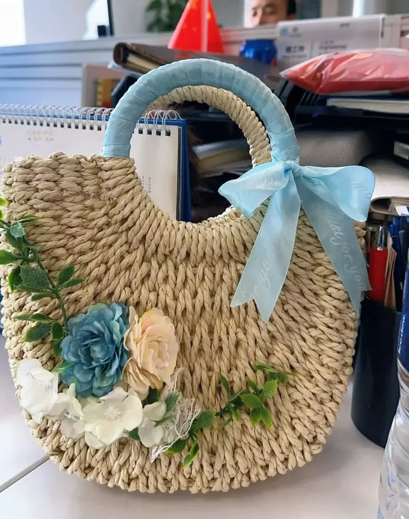 Handwoven bag with floral decoration for employees, an example of company swag ideas for employees