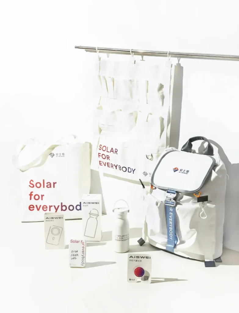 Example of company swag items including a white canvas wall organizer, carry handle water bottle, phone grip stand, and white canvas backpack