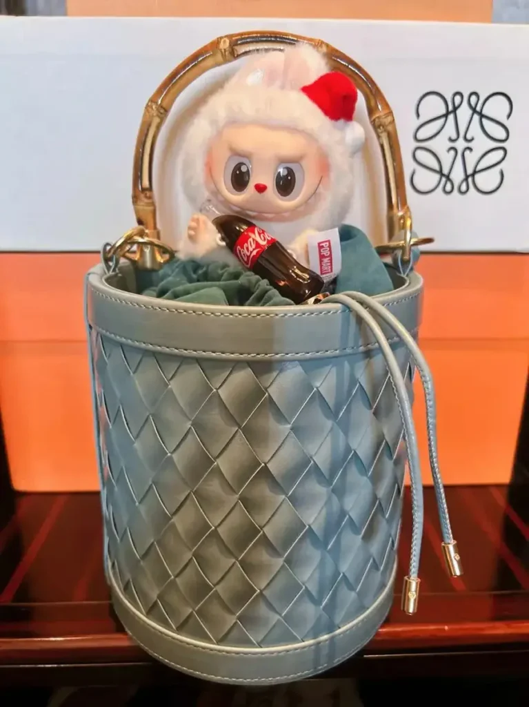 Kurv Bedriftsgaveideer som føles moderne, nyttige og minneverdige 1 En moderne, blå, flettet kurv i lær med en trendy designerleke fra Labubu.