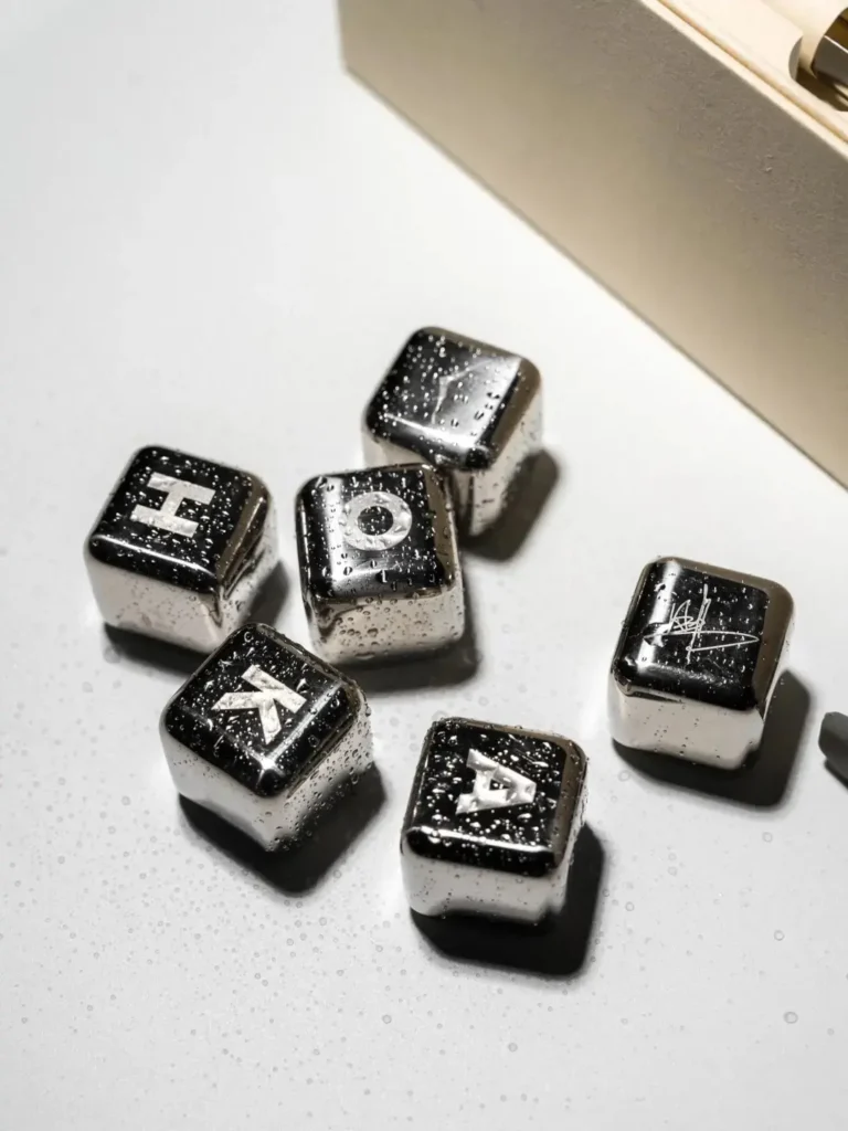 Close-up of a custom engraved stainless steel ice cube showing subtle corporate branding, an example of premium sustainable corporate gifts by LUGVO.