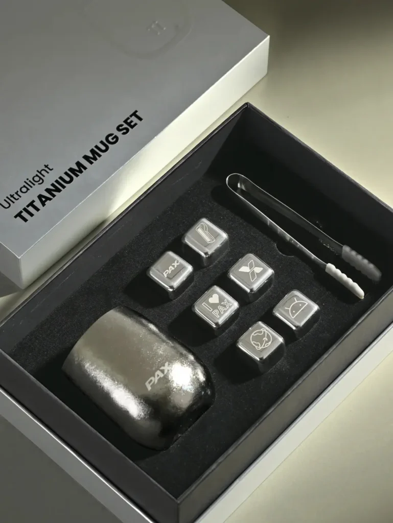 Opened titanium cup gift box displaying a titanium cup, six ice cubes, and an ice tong as premium branded merchandise for client gifting.